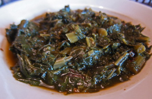a white bowl of cooked leafy greens